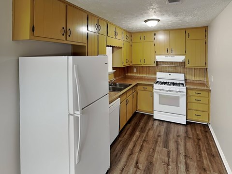 A kitchen with wooden cabinets and a white refrigerator.