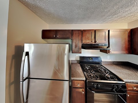 A kitchen with a stove and refrigerator.