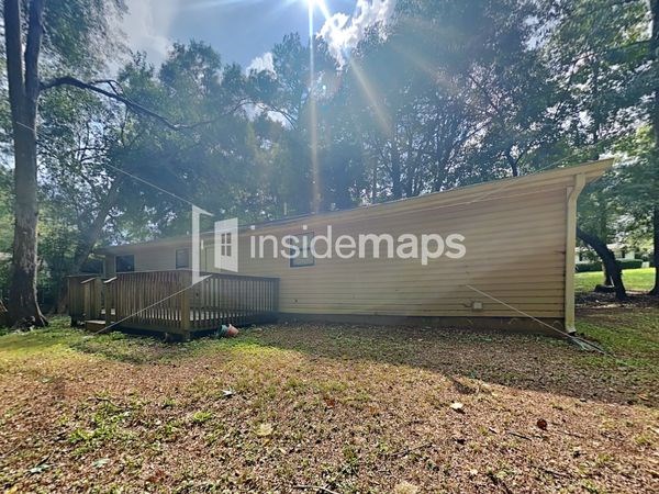 a tiny house in the woods with a shed and a deck