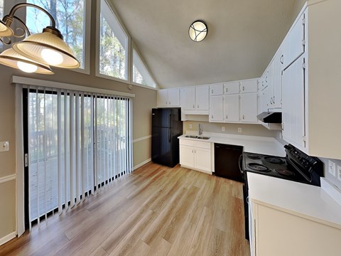 A kitchen with white cabinets and a black stove top oven.