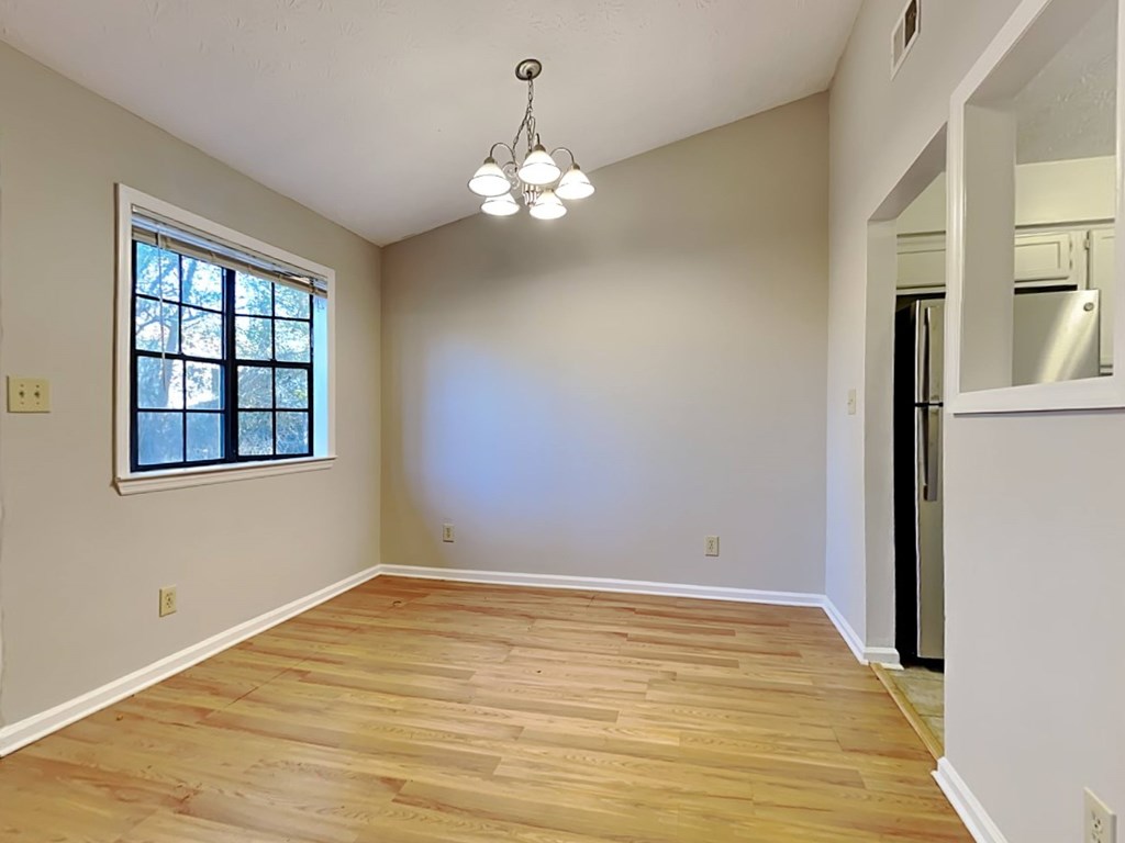 an empty living room with white walls and a window