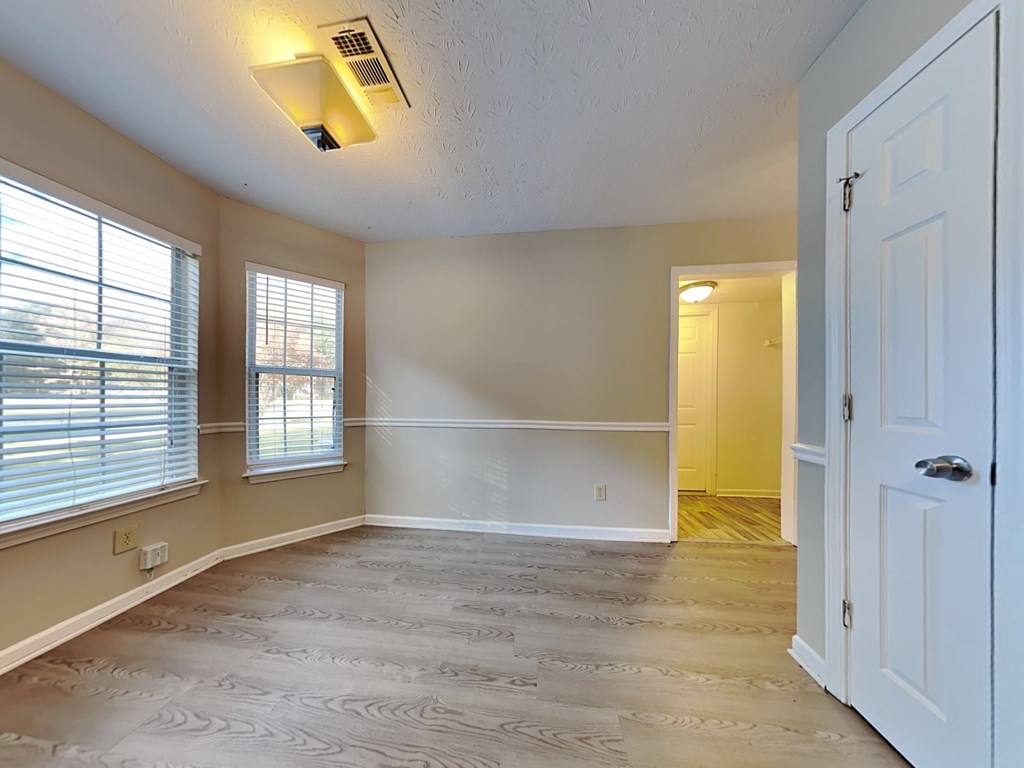 an empty living room with a white door and window