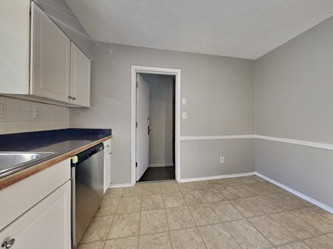 A kitchen with white cabinets and a blue countertop.