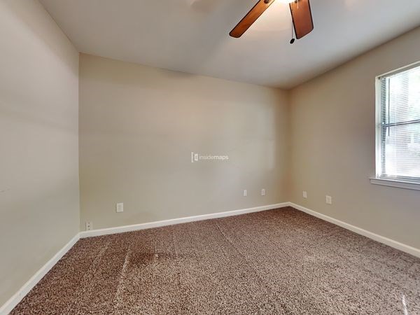an empty room with a ceiling fan and a window