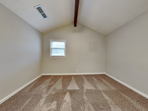an empty room with carpet and a window