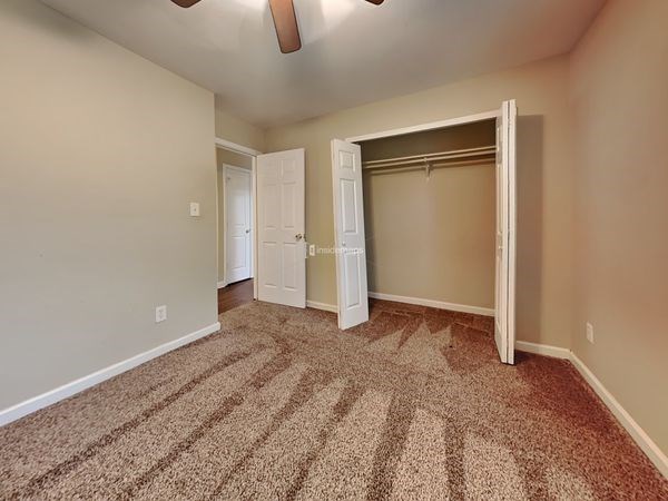 an empty bedroom with a closet and a door