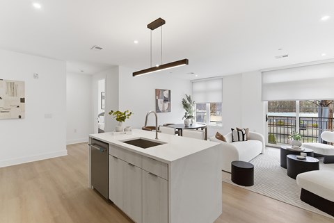 A modern kitchen with a large island and a dining area with a view.