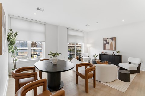 A modern living room with a black table and brown chairs.
