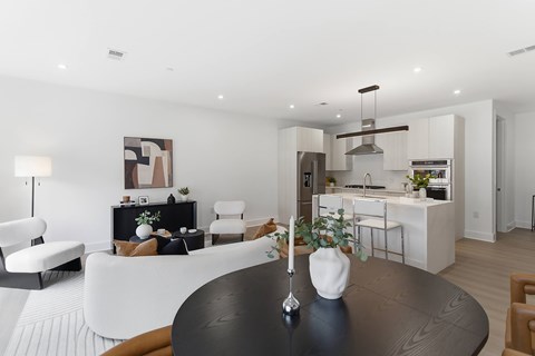 A modern living room with a black table and white furniture.