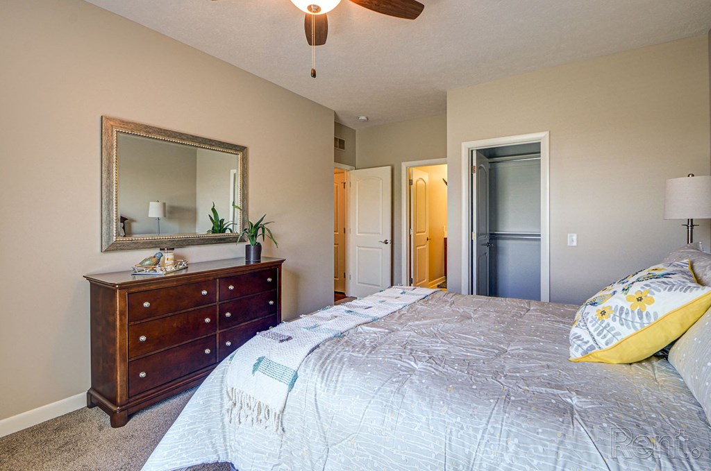 a bedroom with a large bed and a ceiling fan