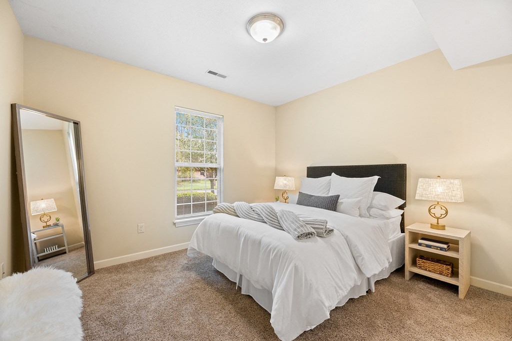 a bedroom with a large bed and a mirror