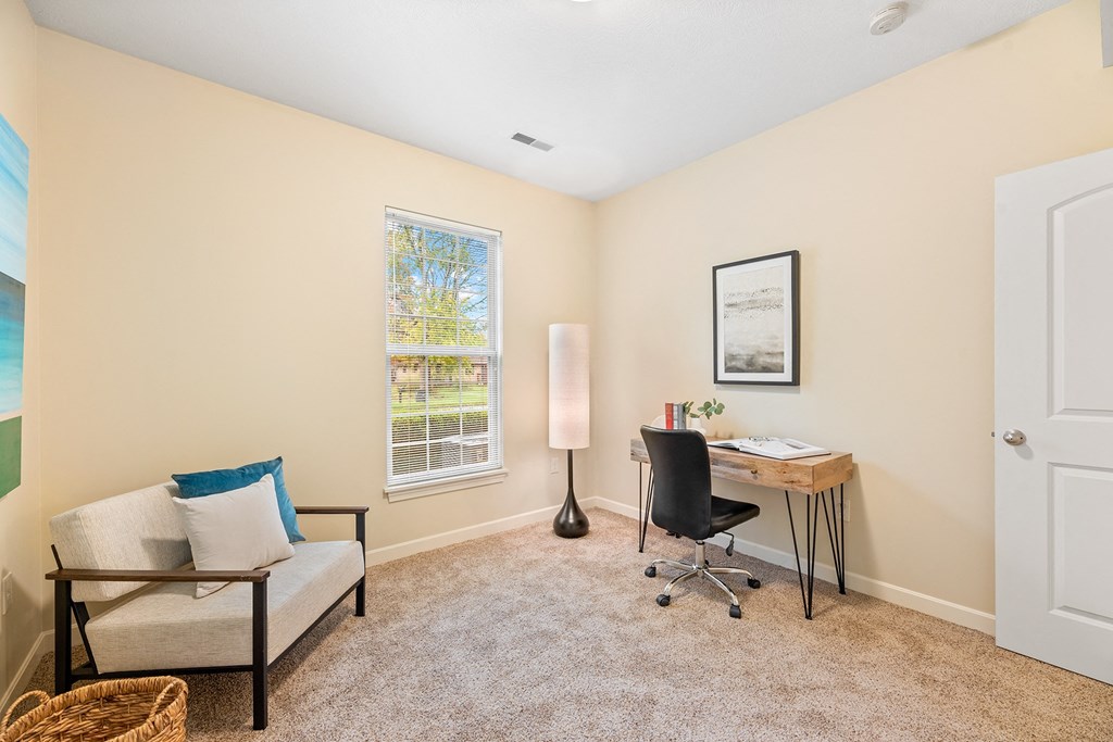 a home office with a desk and chair and a window