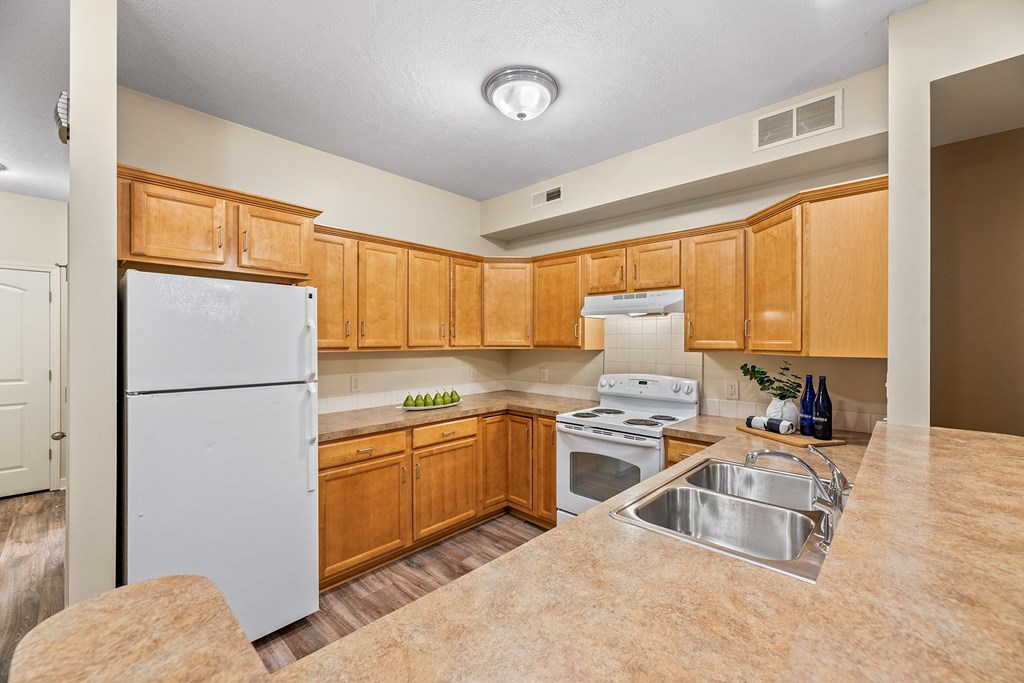 a kitchen with white appliances and wooden cabinets