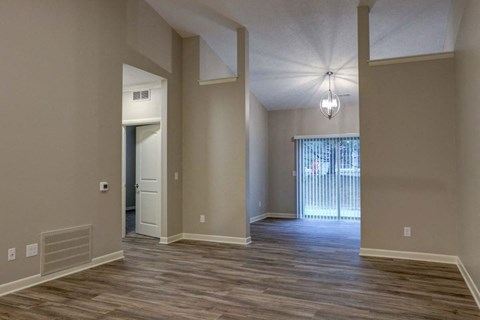 an empty living room with a door to a patio