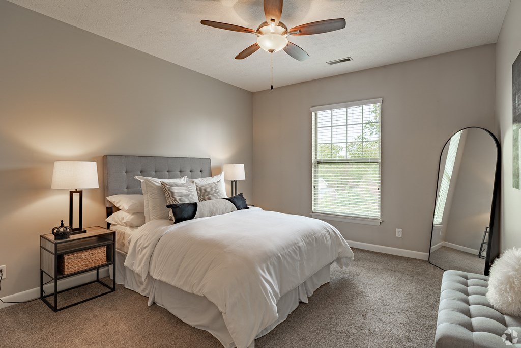 a bedroom with a large bed and a ceiling fan