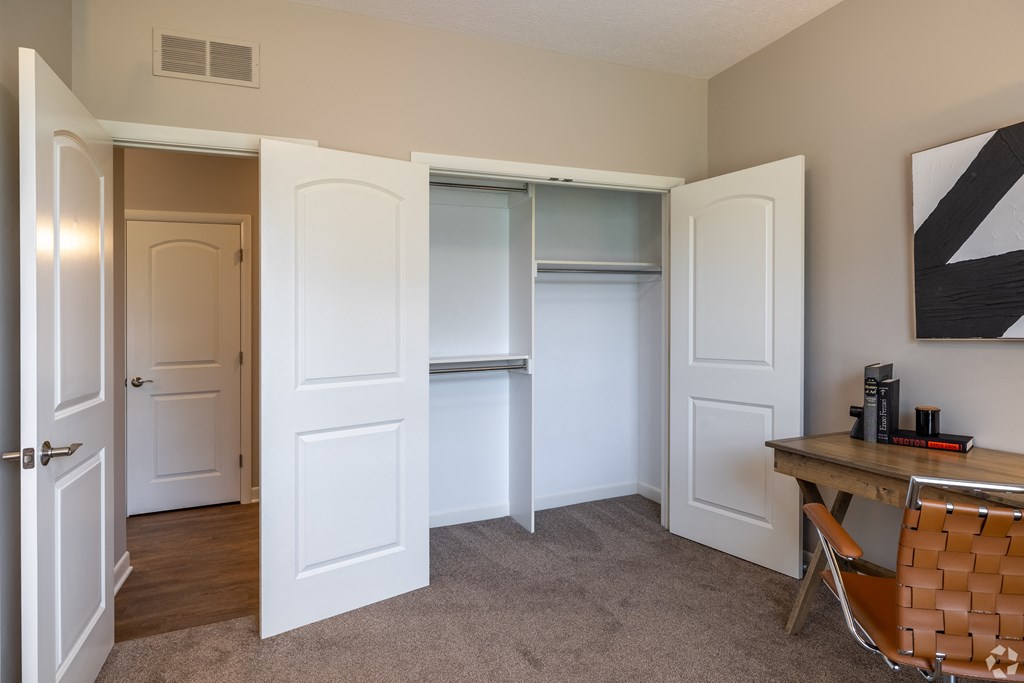 a walk in closet in a living room with doors open