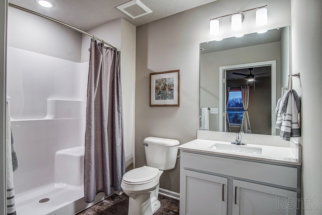 a bathroom with a shower toilet and sink and a mirror