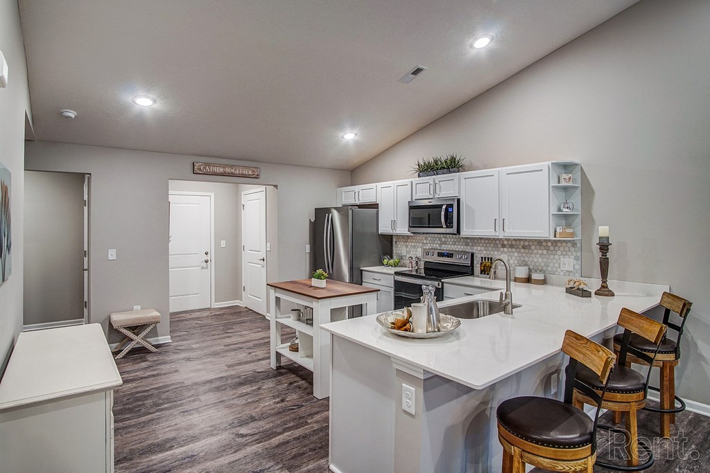 An open kitchen and dining area with a white counter top in a home at Chestnut Hills.