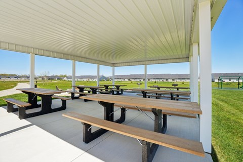 A covered picnic area with tables and benches.