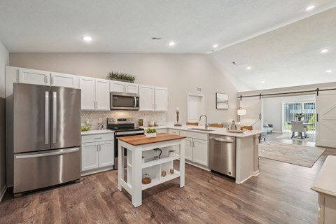 A modern kitchen with a wooden table and stainless steel appliances.