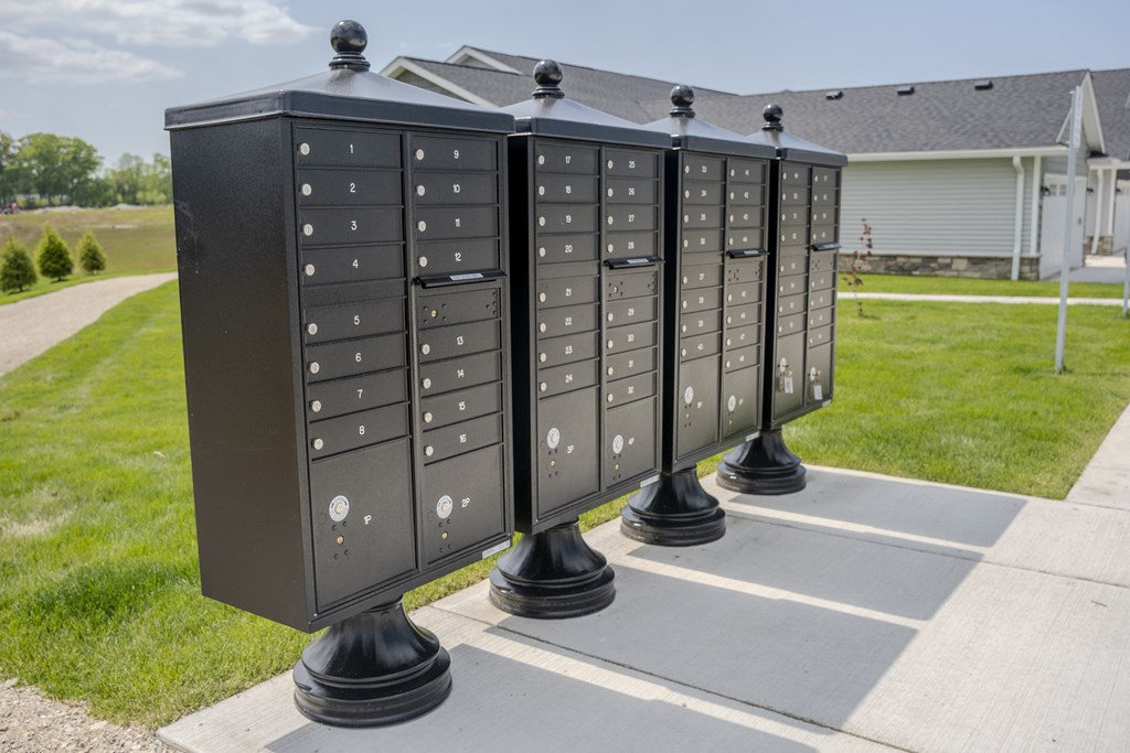 a row of mailboxes are displayed on a sidewalk in front of a house