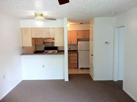 A kitchen with a refrigerator, microwave, and oven.