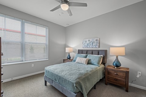 a bedroom with a bed and a ceiling fan