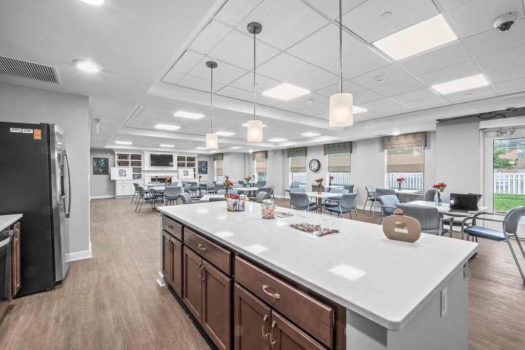 a large kitchen with a large island and chairs in a room with tables and chairs