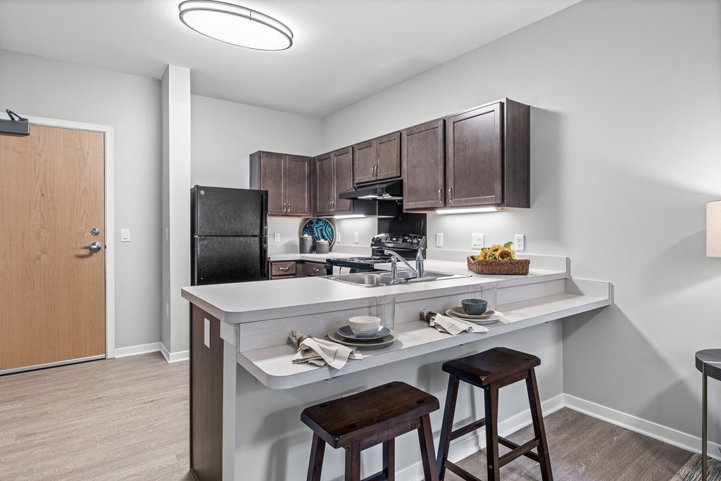 a kitchen with a breakfast bar and stools next to a kitchen counter with a