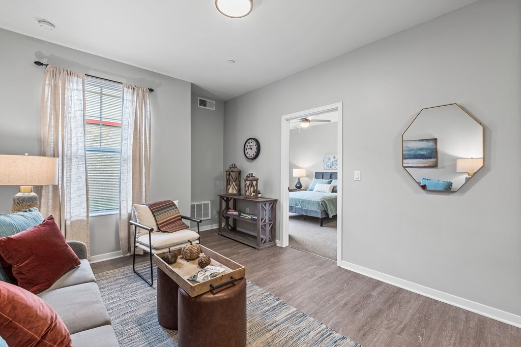 a living room with a couch and a chair and a door to a bedroom