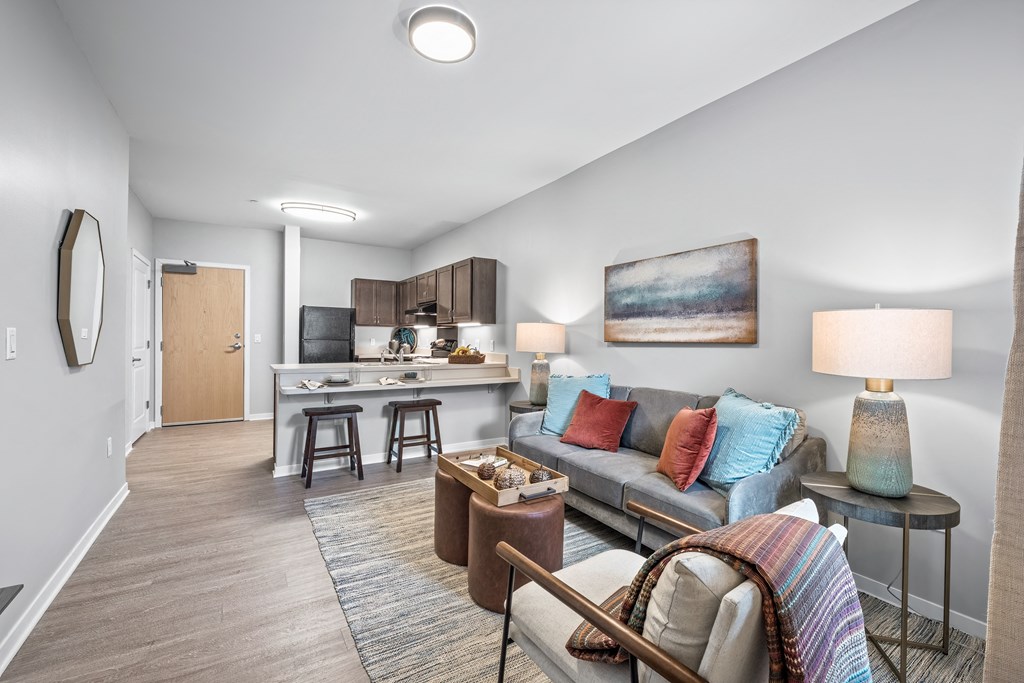 a living room with a couch and a kitchen with a bar