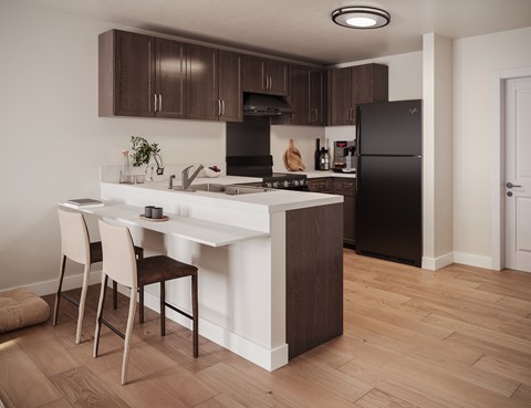 A kitchen with a black refrigerator and brown cabinets.