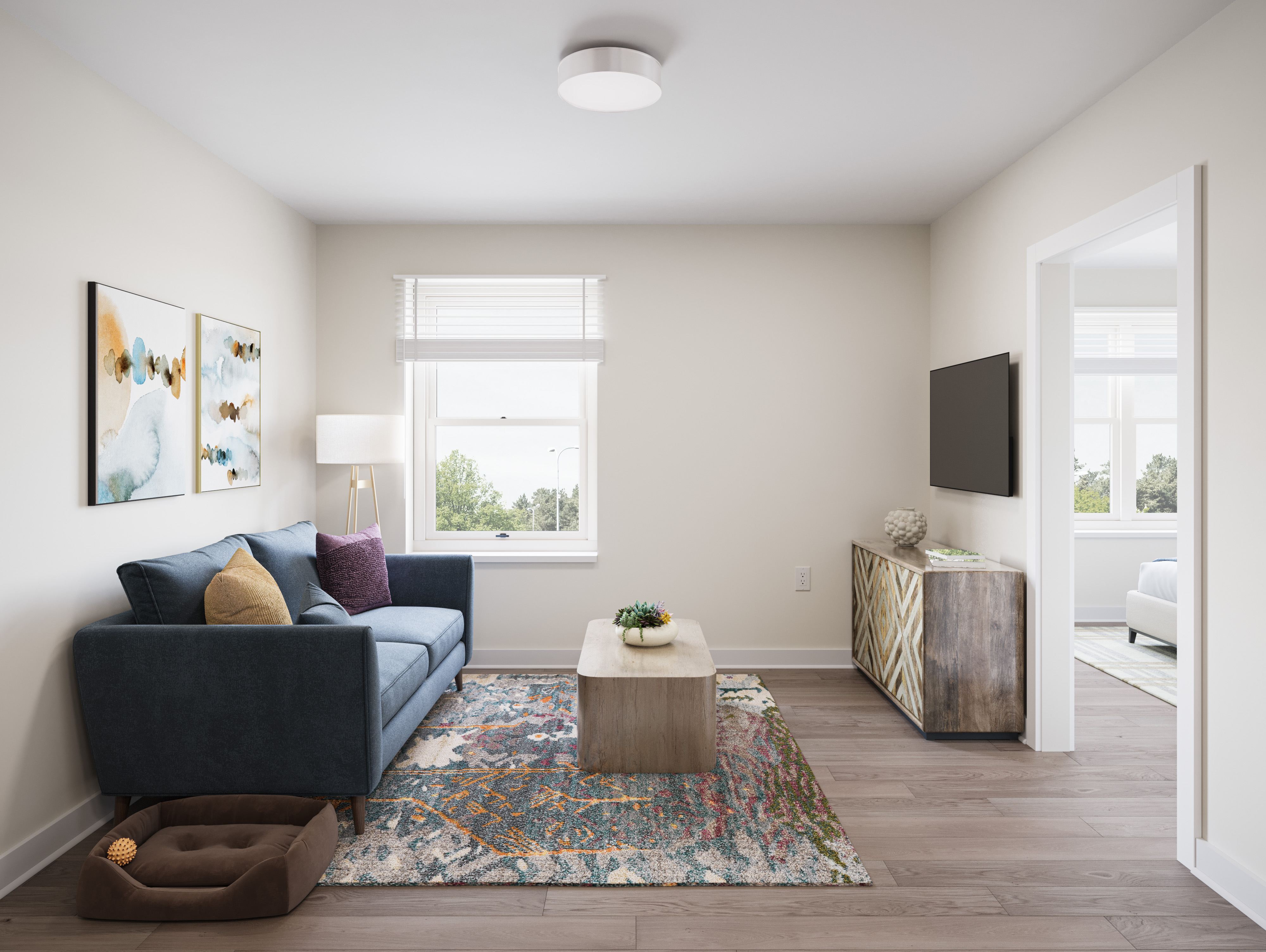 A living room with a blue couch and a rug.