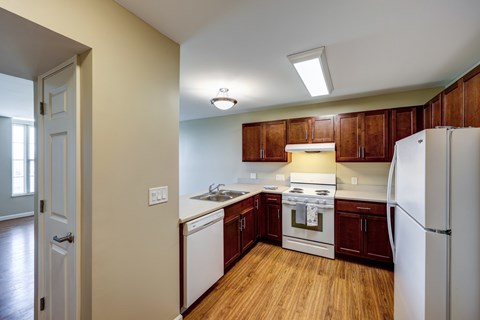 Kitchen with cherry cabinets and white appliances at Avondale Senior Village Apartments, Dublin