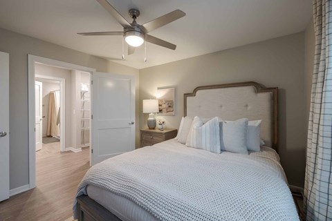 A bedroom with a large bed and a ceiling fan.