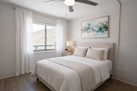 A bedroom with a large bed and a painting on the wall.