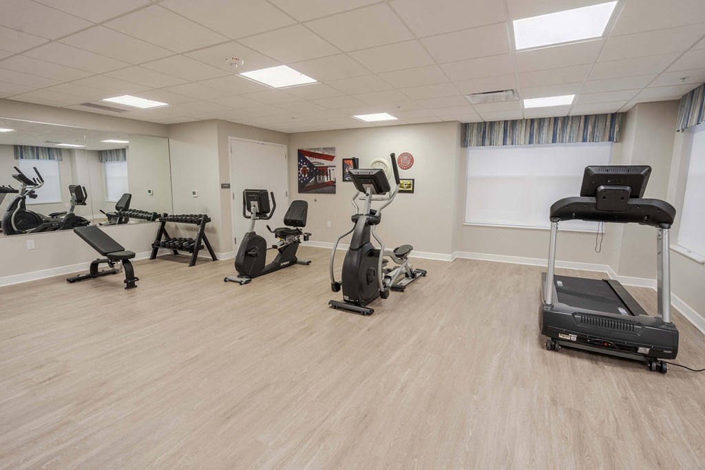 A spacious gym with a variety of cardio equipment.