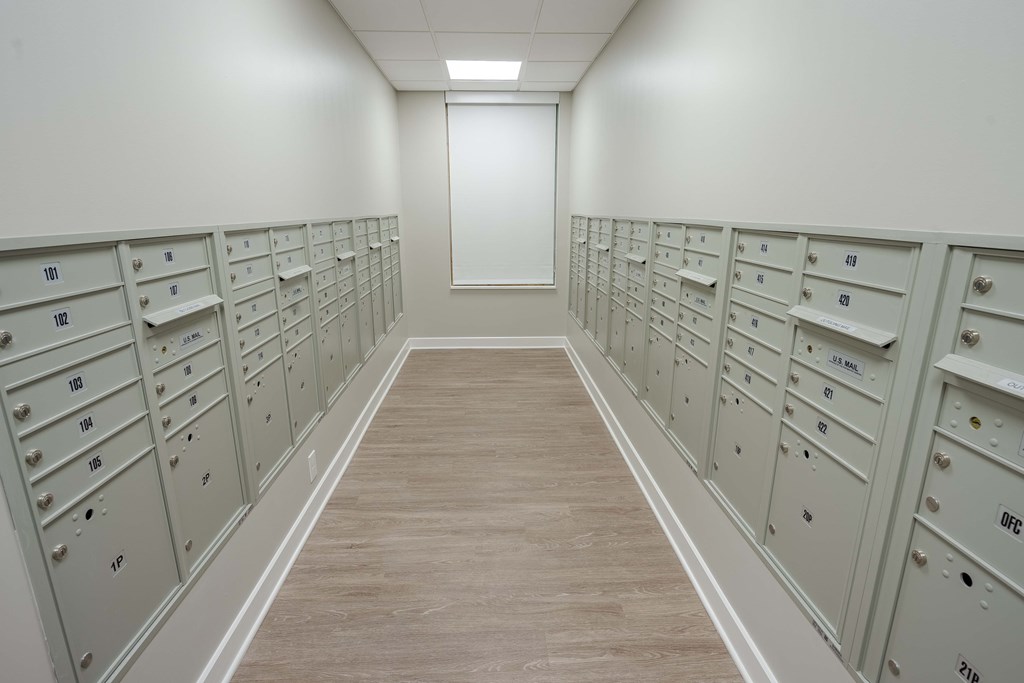 A long hallway with a series of mailboxes on the wall.