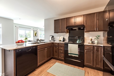 A kitchen with dark wood cabinets and appliances.