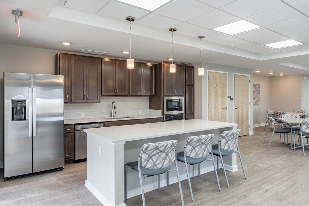 A modern kitchen with a white island and stainless steel appliances.