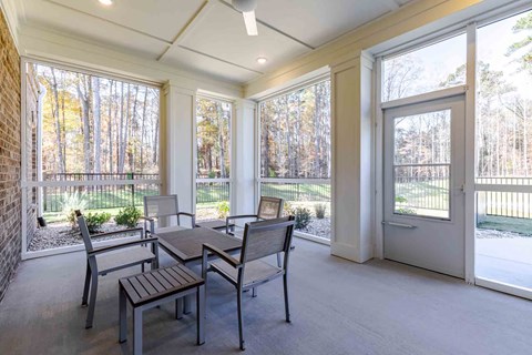 A sunroom with a table and chairs.
