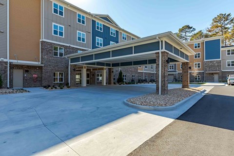 A large multi-story building with a covered walkway entrance.