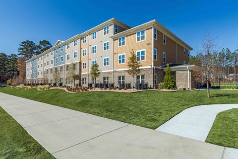 A large apartment complex with a walkway in front.