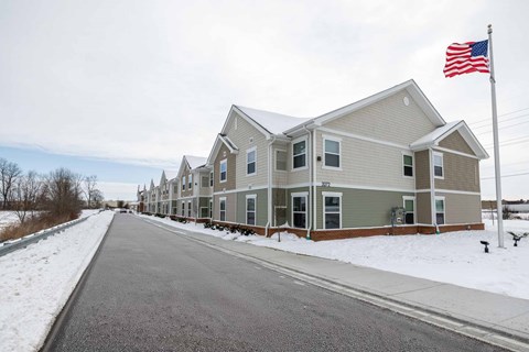 A row of houses with an American flag in front.