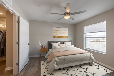 A bedroom with a large bed and a ceiling fan.