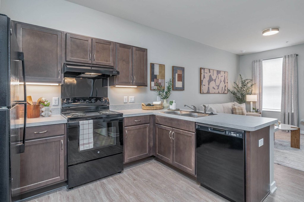 A modern kitchen with dark brown cabinets and black appliances.