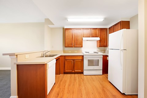 A kitchen with wooden cabinets and white appliances.