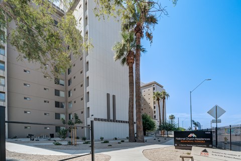 The image shows a modern building with a sign in front that reads "National Church Residences.".