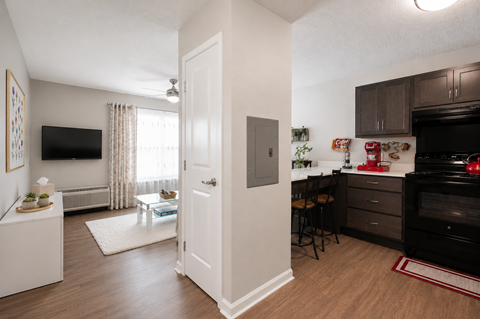 A kitchen with a black stove top oven and a white door.