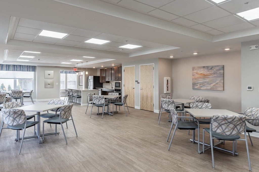A room with a dining table and chairs.